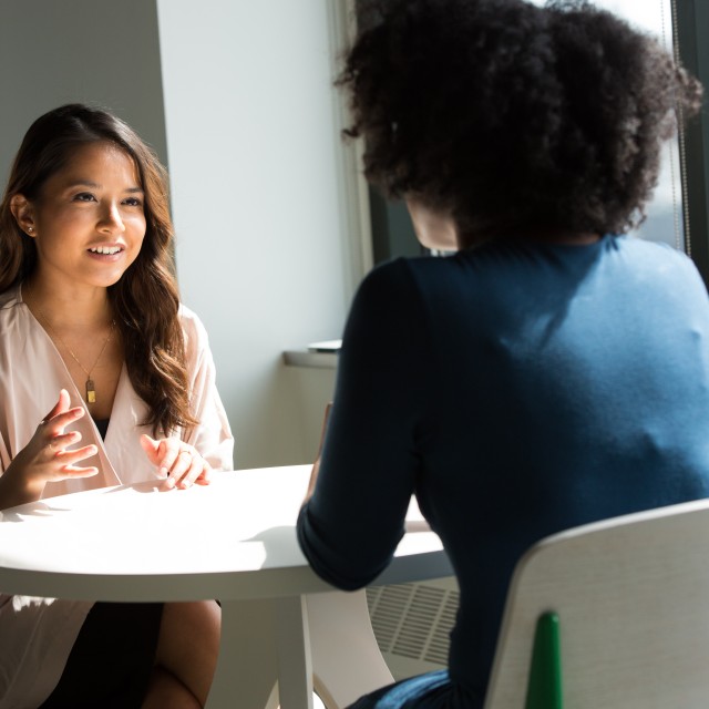 Two women talking at table